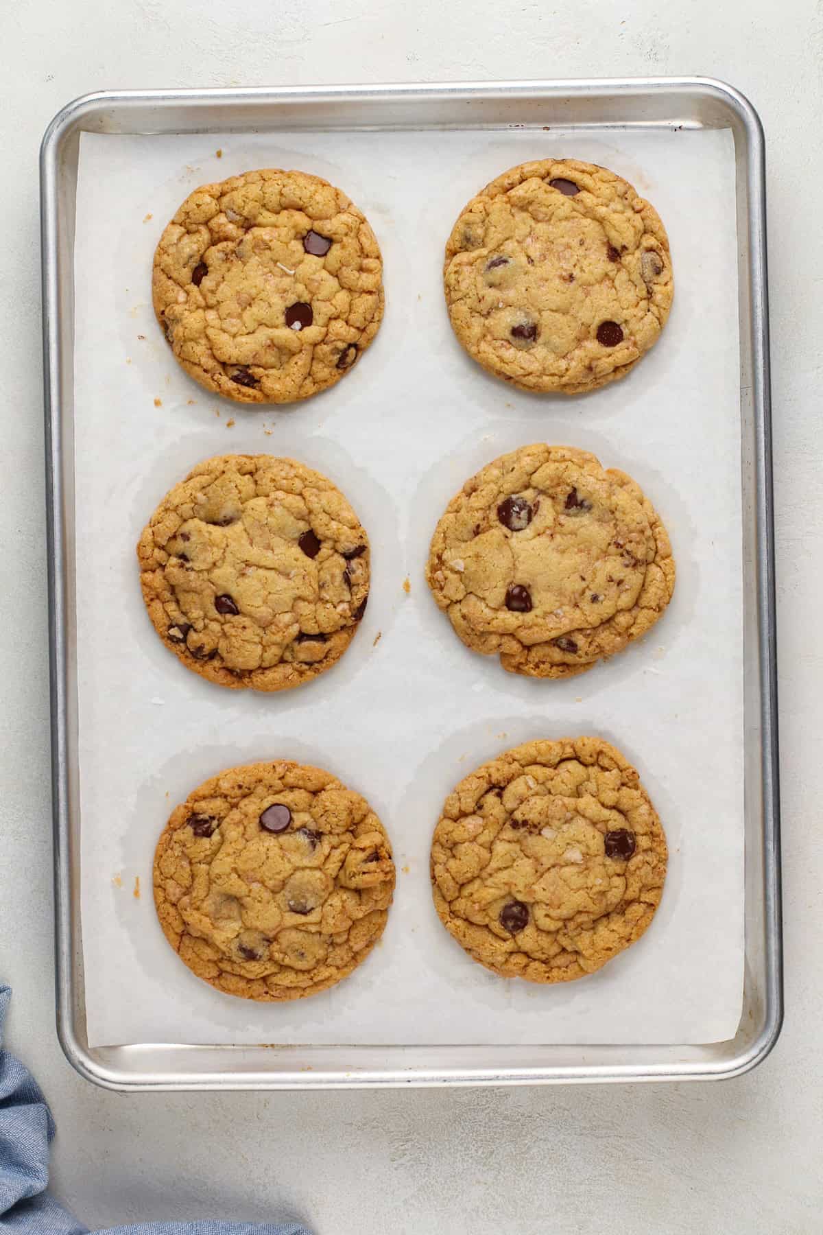 Freshly baked heath bar cookies on a lined sheet pan.