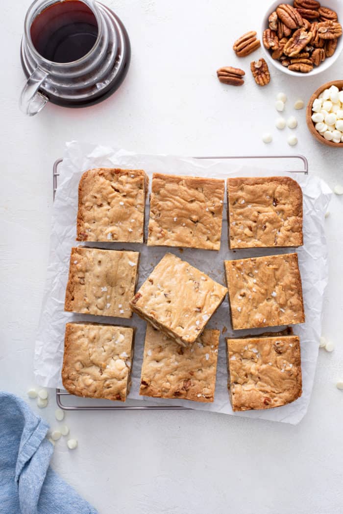 Sliced white chocolate pecan blondies on a wire cooling rack.