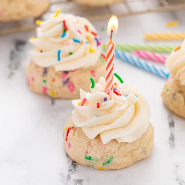 Birthday cake cookie with lit birthday candle in it.