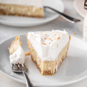 Front view of a plated slice of coconut cream pie with a bite taken from the front