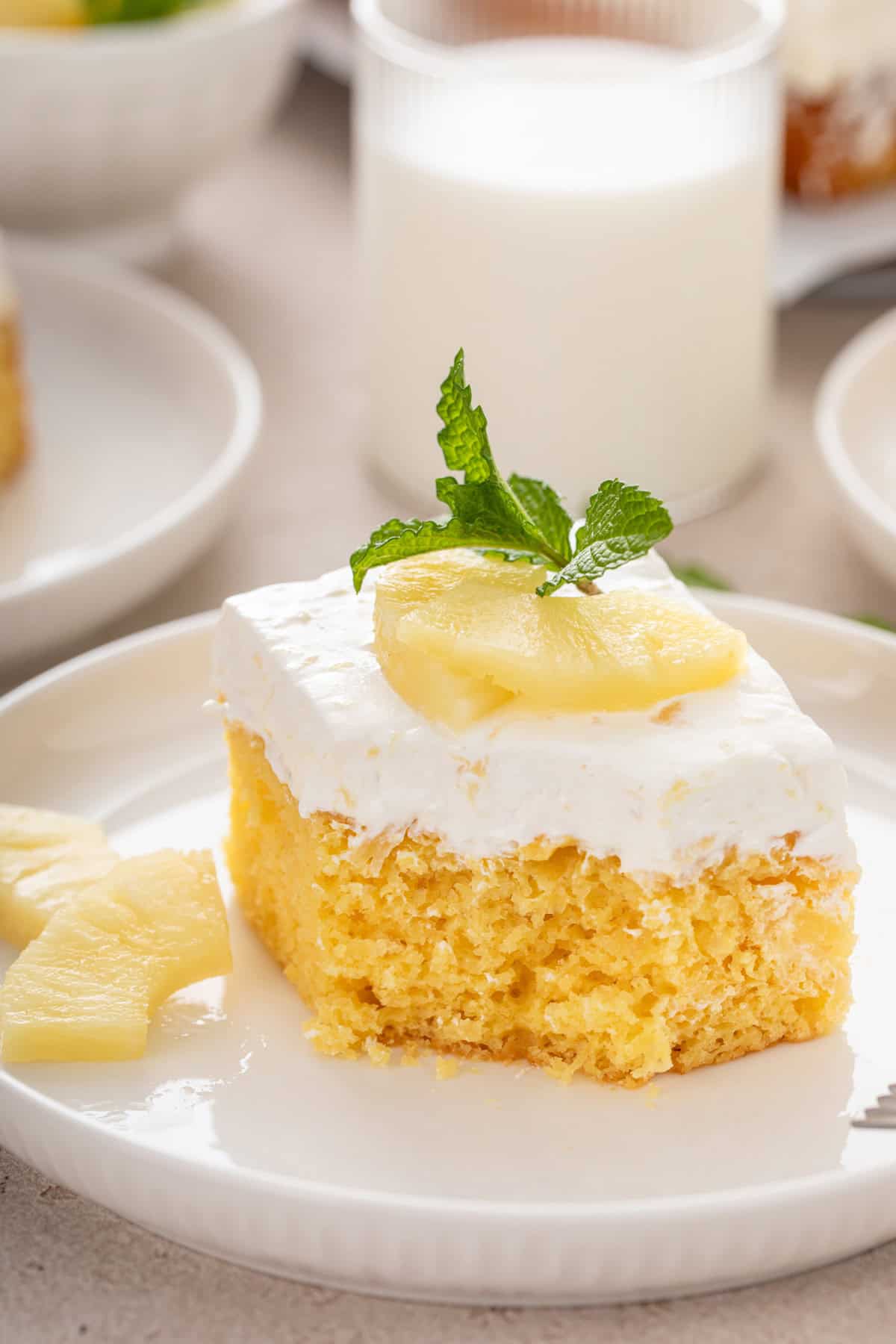 Plated slice of pineapple cake with a bite taken from the corner.