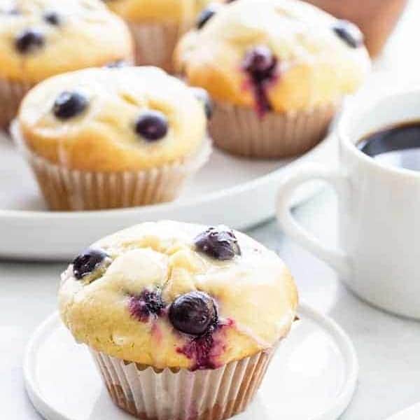 Blueberry doughnut muffin on a small round plate on a marbled surface