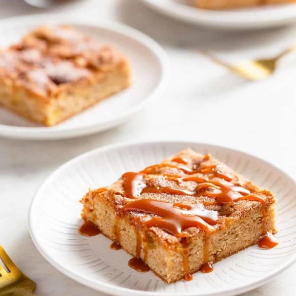 Three white plates with apple bars, each topped with a different topping