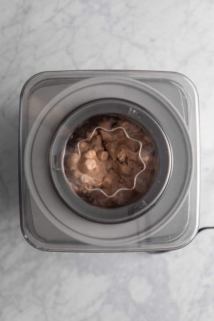 Rocky road ice cream being churned in an ice cream maker.