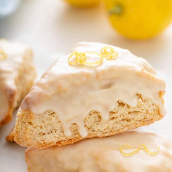 Close up of glazed lemon scone garnished with lemon zest.