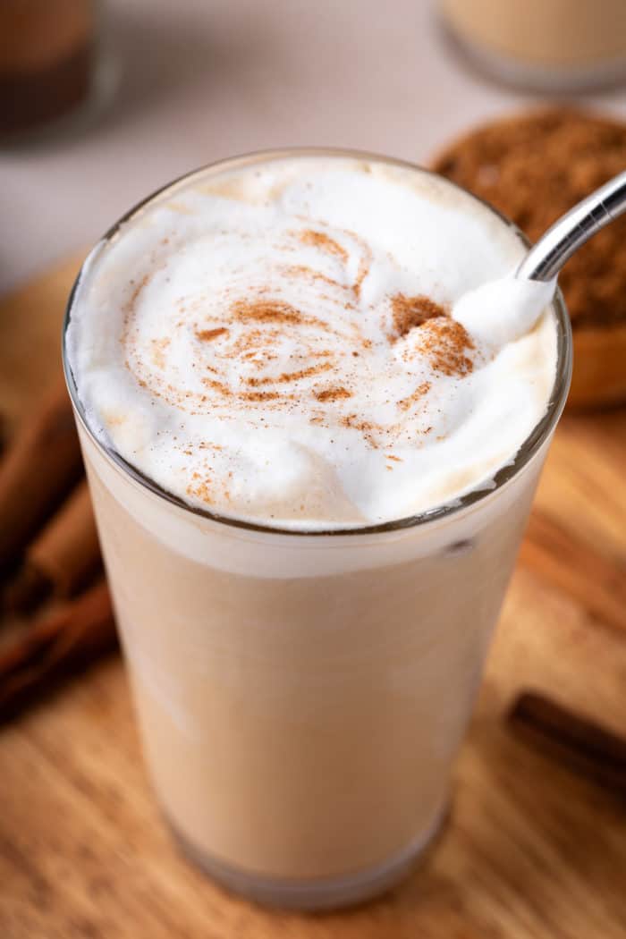 Close up of vanilla sweet cream cold foam dusted with cinnamon on top of a glass of iced coffee.