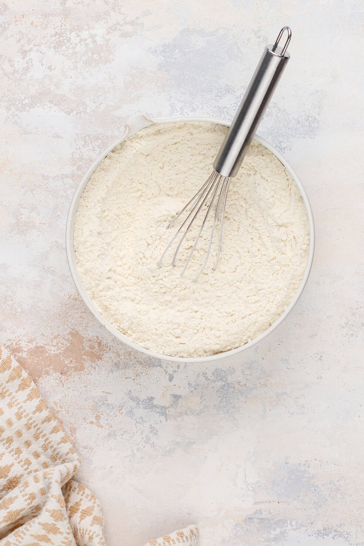 Dry ingredients for coconut sugar cookies in a mixing bowl.