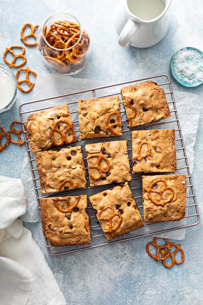 Overhead view of sliced salted caramel blondies with pretzels on a metal cooling rack