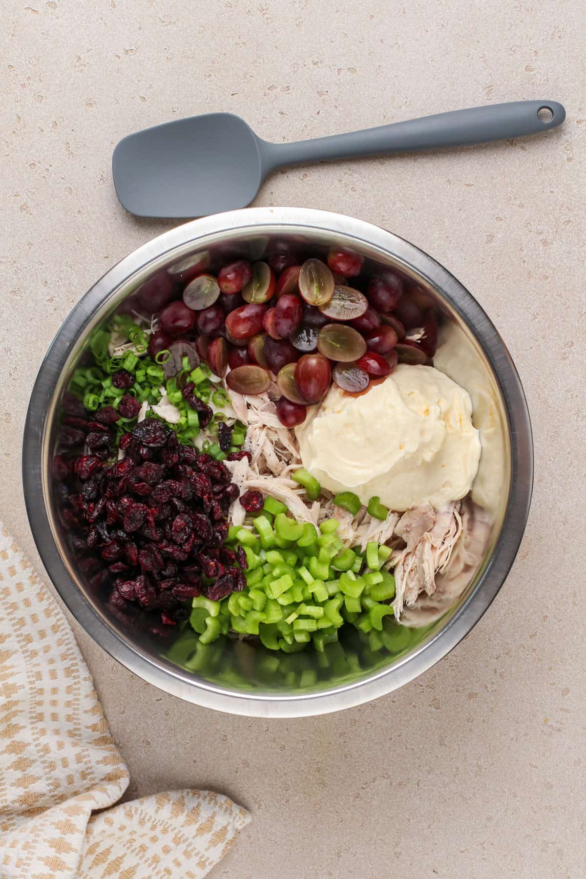 Ingredients for cranberry chicken salad added to a metal bowl.