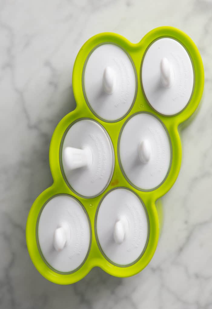 Filled popsicle mold set on a marble countertop.