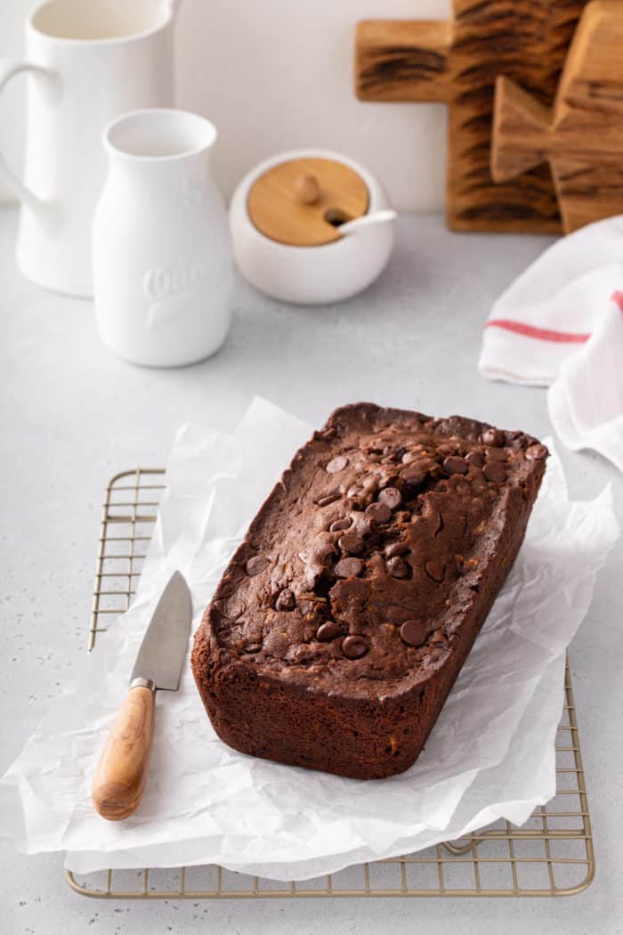 Freshly baked loaf of chocolate zucchini bread on a piece of parchment paper.