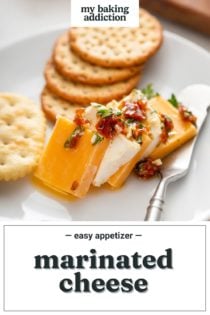 Several pieces of marinated cheese next to crackers on a white plate. Text overlay includes recipe name.