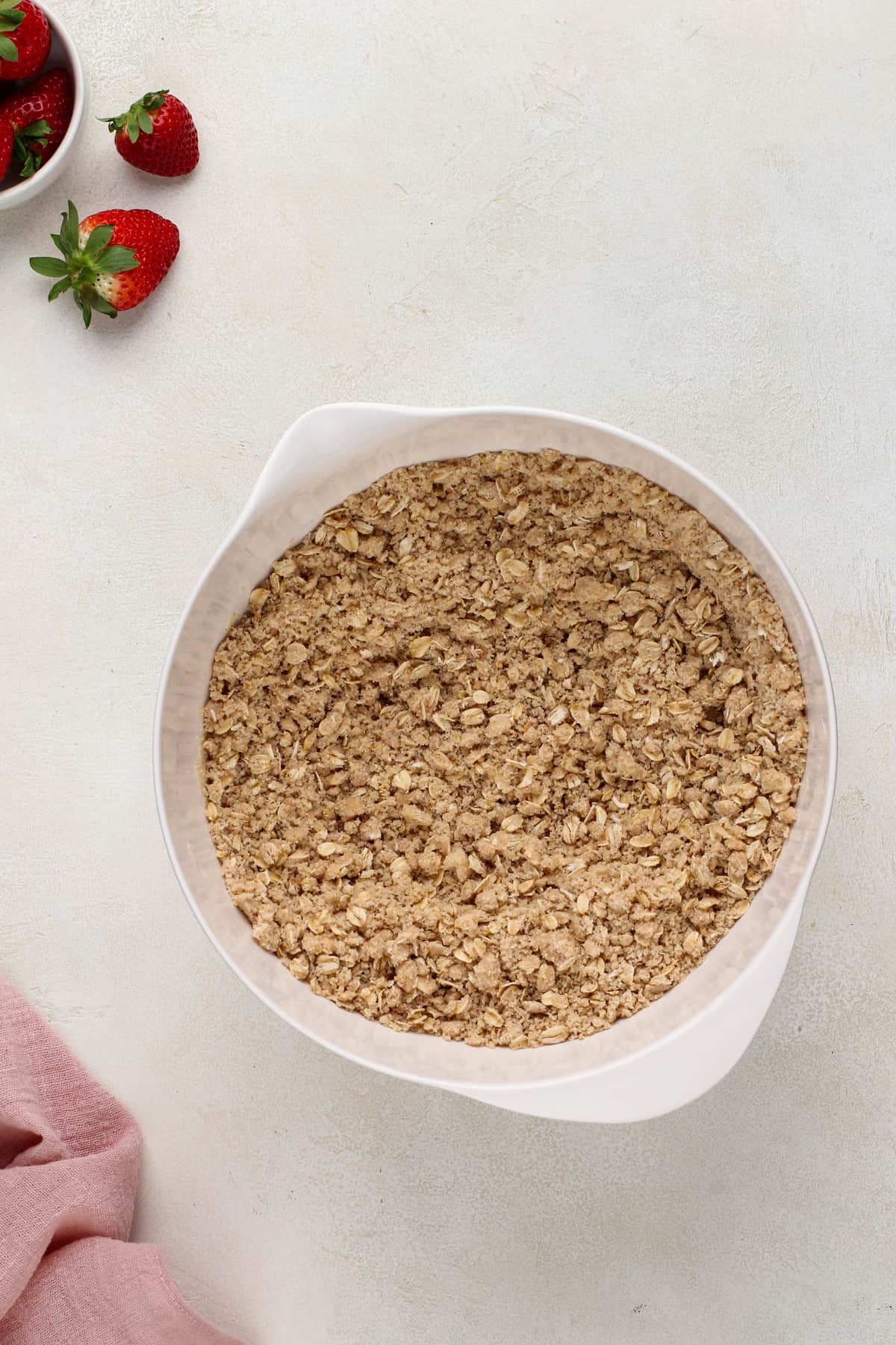 Crust mixture for oatmeal bars in a white mixing bowl.