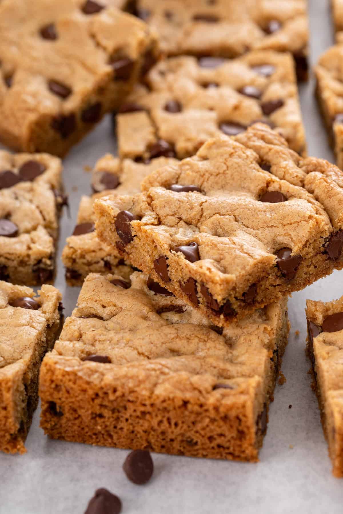 Sliced chocolate chip cookie bars arranged on a countertop.