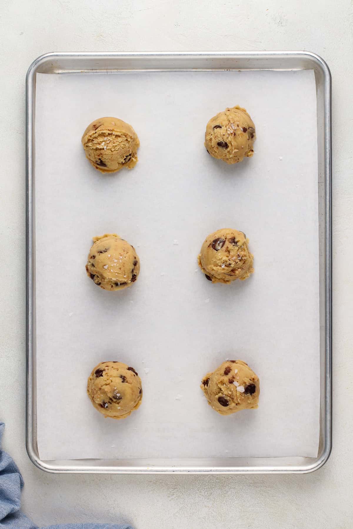 Portioned heath bar cookie dough on a sheet pan, ready to be baked.