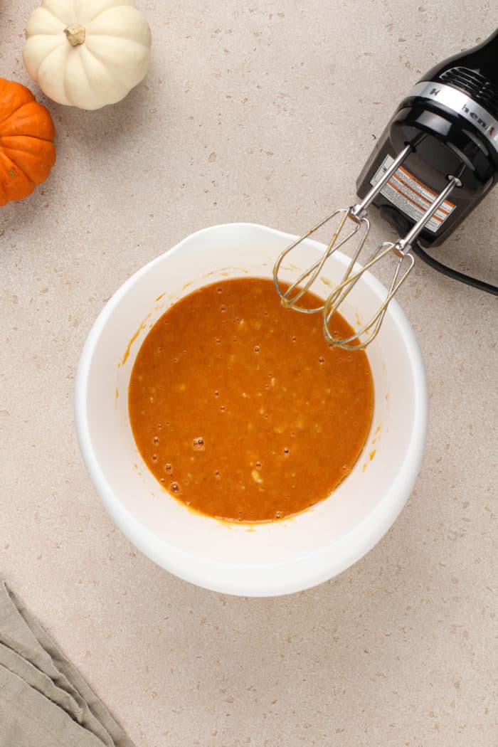 Wet ingredients for pumpkin banana bread in a mixing bowl.