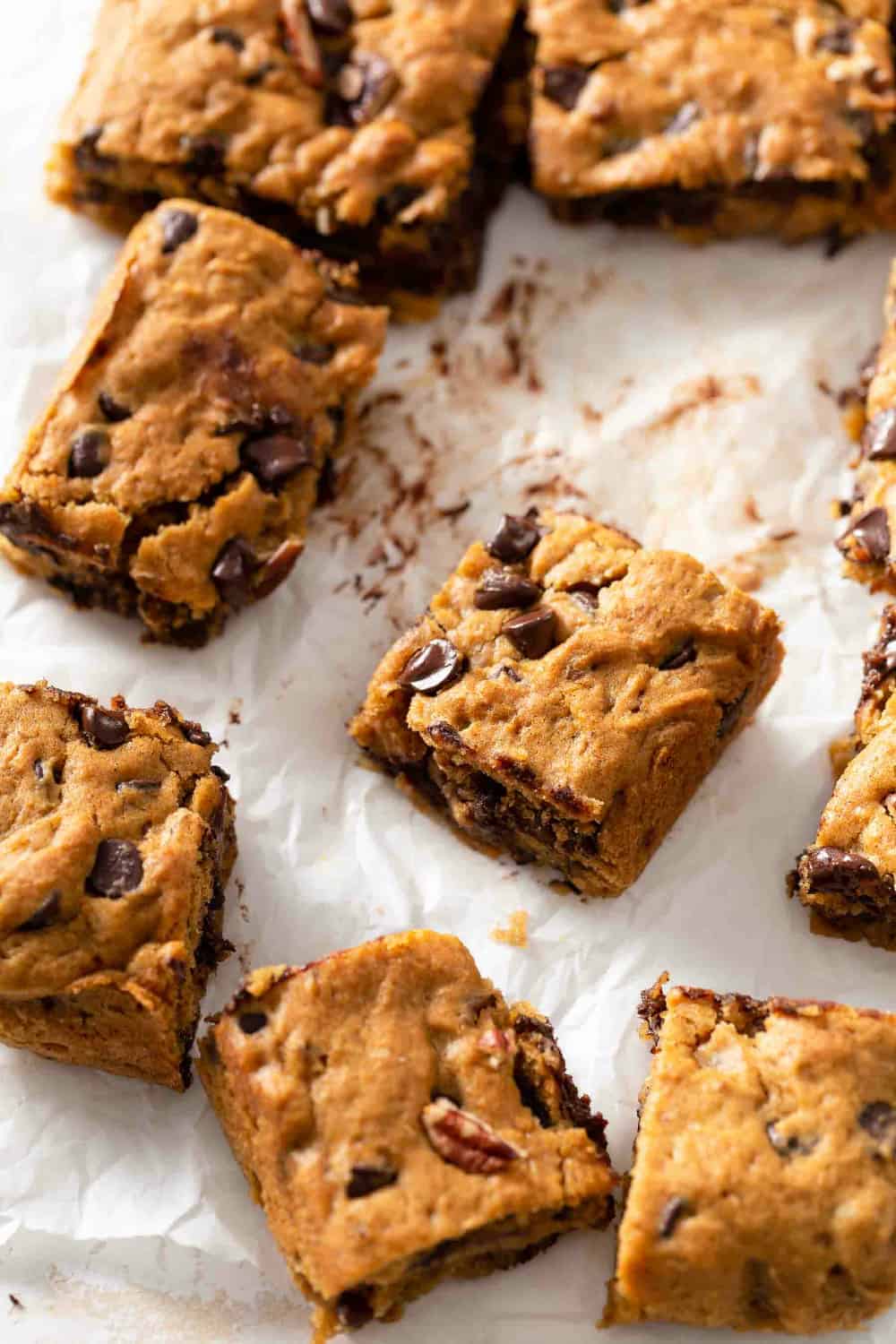 sliced warm, gooey pumpkin blondies on a piece of parchment