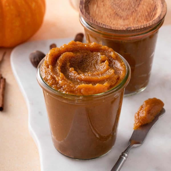 two pumpkin butter jars on white tray