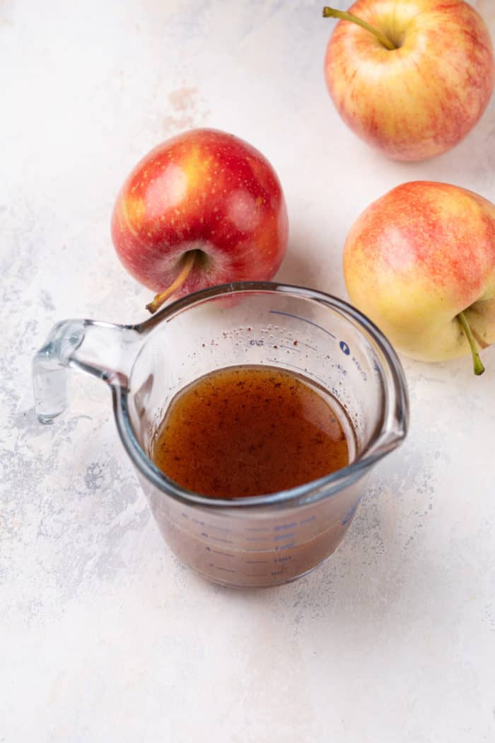 Glass measuring cup with reduced apple cider in it.