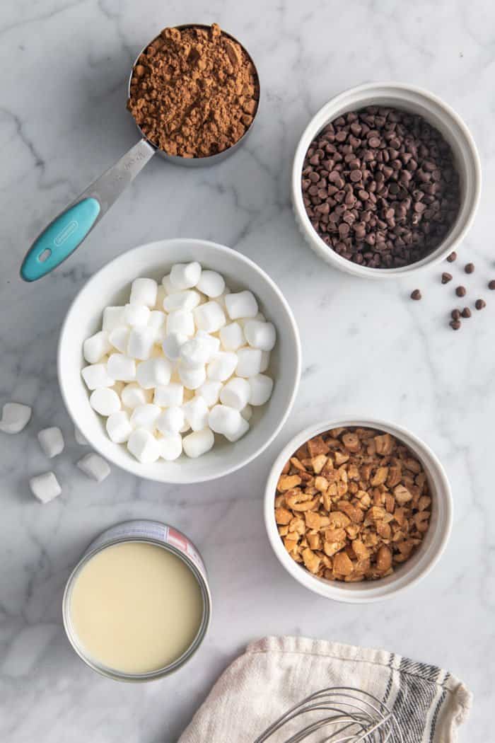 Rocky road ice cream ingredients arranged on a marble countertop.