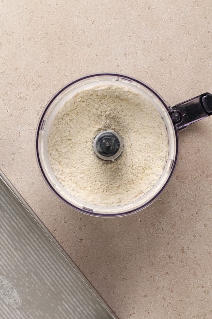 Shortbread crust ingredients pulsed in a food processor, ready to be pressed into a pan.