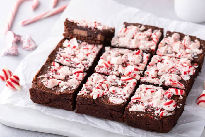 Sliced pan of peppermint brownies on a pan of parchment paper.