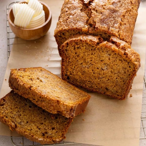 Sliced loaf of pumpkin banana bread on a piece of parchment paper.