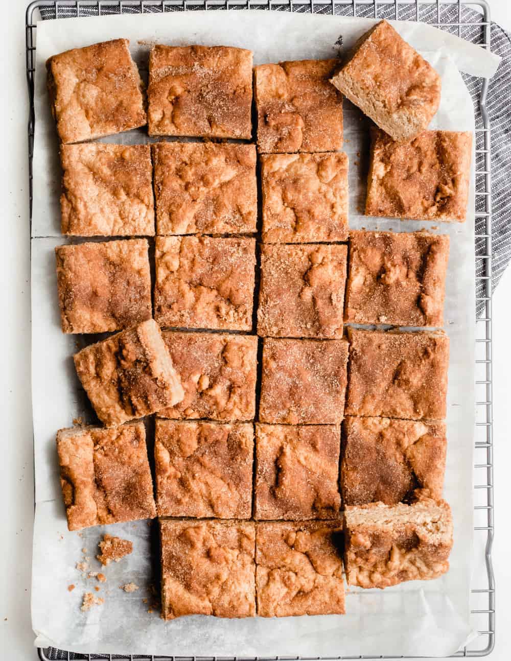 Snickerdoodle blondies scattered on a cooling rack