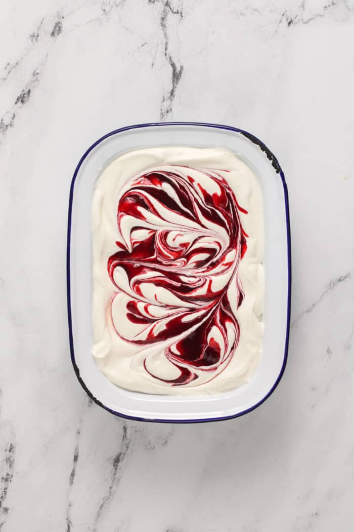 Strawberry swirl no-churn ice cream in a freezer container, ready to go in the freezer.