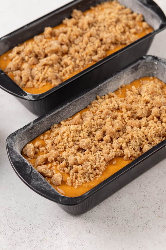 Two unbaked loaves of streusel-topped pumpkin bread ready to go in the oven.